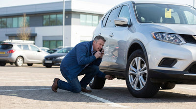 A car hire vehicle parked on a quiet, palm tree-lined street in Los Angeles at night