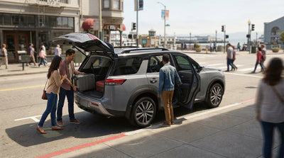 A silver car hire parked on a street by San Francisco's Fisherman's Wharf with the bay and boats in the background