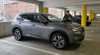 A modern car rental is stopped at the exit barrier of a multi-level parking garage in Philadelphia