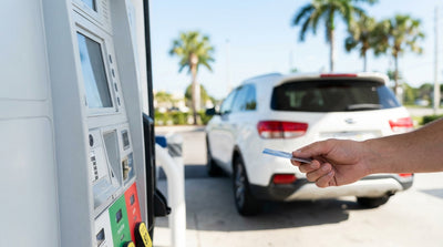 A person fueling their car hire at a gas station pump on a sunny day in Florida