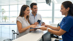Traveler handing paperwork to an agent at a Miami Airport car rental counter