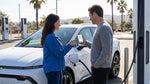 Person plugging a charging cable into an electric car rental under sunny palm trees in California