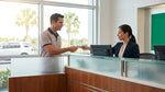 Close up of a hand passing a credit card to an agent at an Orlando car hire desk