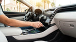 Hand plugging a phone charging cable into the dashboard USB port of a Las Vegas car rental