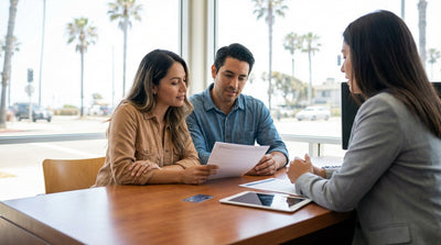 A white convertible car rental driving on a winding coastal highway in California on a sunny day
