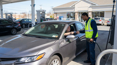 A modern car rental drives on a bridge with the yellow cabs and skyscrapers of New York in the background