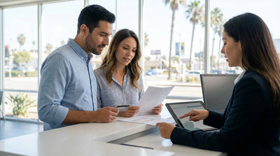 A convertible car rental driving down a sunny coastal highway in California with ocean views