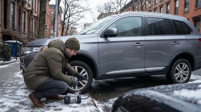 A car rental dashboard with the tire pressure warning light illuminated on a snowy winter day in New York