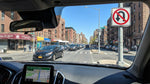 Driver's view from a car hire of a busy street with yellow cabs and traffic in New York City