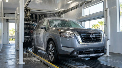 A modern car hire vehicle going through an automatic car wash with soap and rotating brushes in Orlando