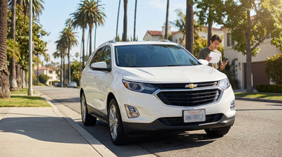 Police car with flashing lights pulling over a sedan car hire on a sunny Los Angeles freeway