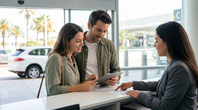 A modern car hire vehicle drives on a scenic coastal highway in the United Estates on a sunny day
