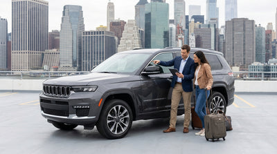 A modern car hire driving down a busy New York City street surrounded by yellow taxis and skyscrapers