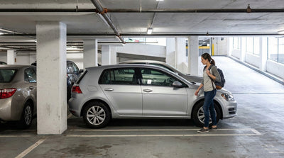 A compact car hire parked in a tight spot inside a multi-level New York parking garage