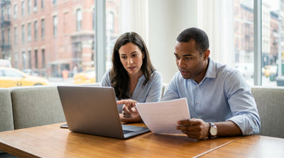 A modern car rental driving on a busy street in New York City with skyscrapers in the background