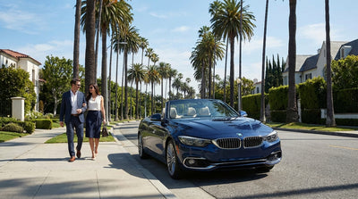 A luxury BMW car rental driving down a palm-lined boulevard in sunny Los Angeles
