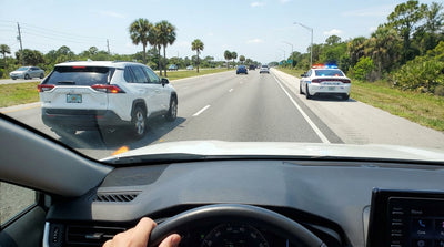 A car hire driving on a sunny highway lined with tall palm trees in Orlando, Florida