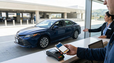 A traveler uses a smartphone to complete a car rental transaction at an SFO airport counter in San Francisco