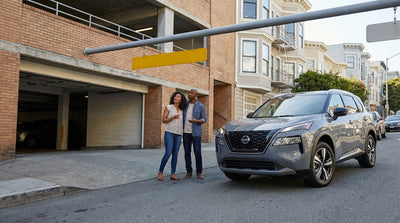 A car rental SUV pauses at a San Francisco parking garage entrance to check the yellow height clearance sign overhead