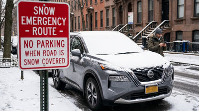 A snow-covered car rental parked on a residential New York City street after a heavy winter storm