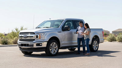 A modern sedan car rental driving down a scenic highway in the Texas countryside on a sunny day