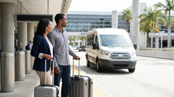 Shuttle bus picking up passengers with luggage at an off-airport car rental lot in Orlando