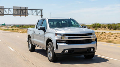 A red car rental driving down an open highway in Texas under a vast, sunny sky
