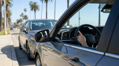 A modern car hire parked on the shoulder of a scenic, sun-drenched California highway