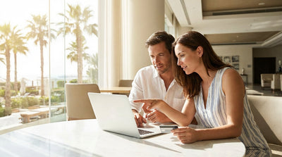 A couple drives a convertible car rental down a scenic, palm-lined coastal highway in Florida