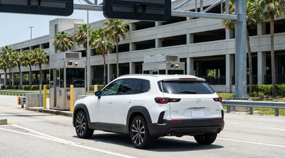 A red convertible car rental driving down a scenic coastal highway in Florida on a bright, sunny day