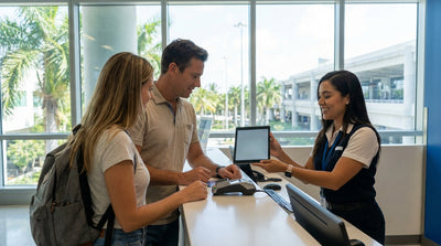 A modern car rental parked on a sunny Miami street with palm trees and art deco buildings in the background