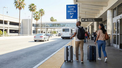 A purple sign directs travelers to the car rental shuttle stop outside a busy LAX terminal in Los Angeles
