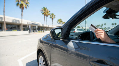Close up of a customer handing a credit card to an agent at a car rental desk in California