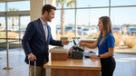 Customer handing a credit card to a booking agent at a car hire desk in Texas