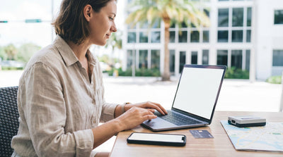 A white car rental driving under a SunPass toll gantry on a sunny highway in Florida with palm trees