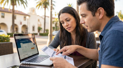 A red convertible car hire driving on a scenic road along the sunny California coast