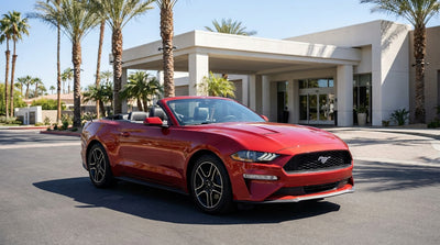 A person's view from inside a car hire showing an automatic gearbox and a sunny California road ahead