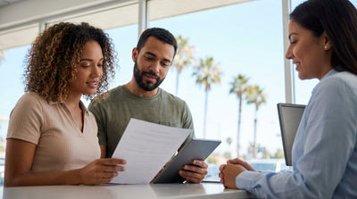 A convertible car hire driving on a winding coastal road under the bright California sun