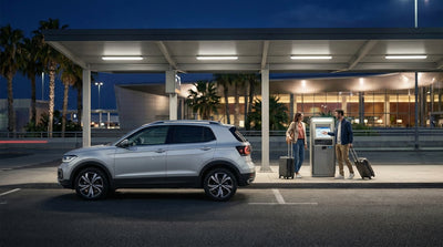 A modern car hire vehicle on a street in Miami with the glowing downtown skyline visible at night