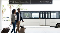 Traveler pulling luggage toward a car rental counter at San Francisco airport