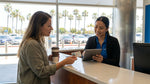 Customer handing a driving licence to a clerk at a car hire desk in California