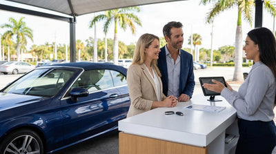 A modern car rental driving on a sunny road lined with palm trees in Florida