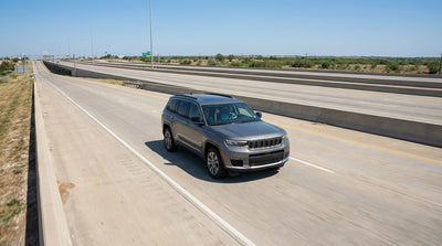 A car hire driving on a service road parallel to a multi-lane highway in sunny Texas