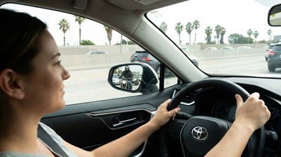 View from a Los Angeles car hire on a sunny freeway with a motorcycle lane-splitting between cars