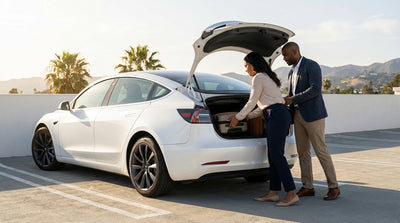 A white Tesla Model 3 car rental charging at a Supercharger station in sunny California