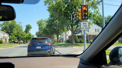 A car rental stopped at a red traffic light on a city street intersection in Pennsylvania