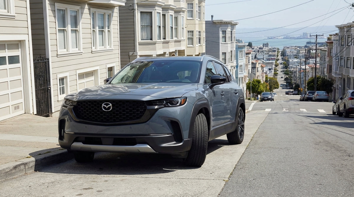 A car rental parked on a steep San Francisco street with its front wheels turned sharply into the curb