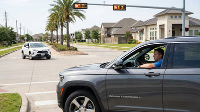 A driver's view from a car hire stopped at a busy intersection with traffic lights in Texas