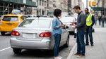 A minor collision involving a car hire vehicle on a bustling street in New York City
