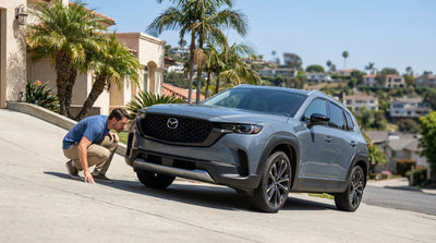 A modern car rental carefully positioned on a steep, narrow driveway in the Los Angeles hills